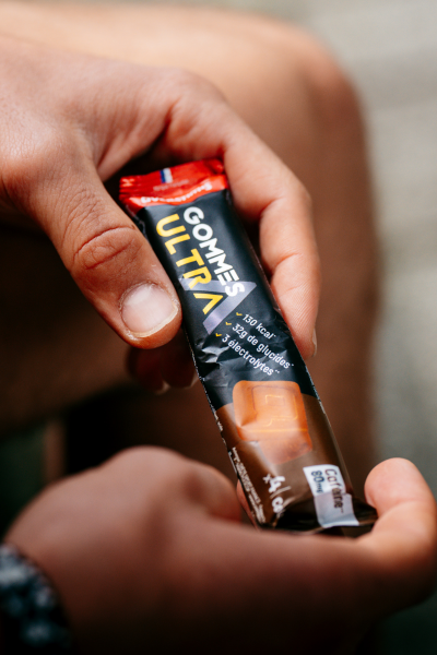 Stick de gommes ultra cola overstims dans les mains d'un triathlète.